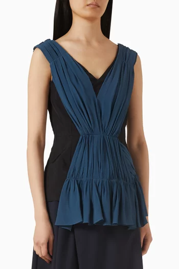 بلوزة بفتحة رقبة على شكل حرف V وكشكش تويل