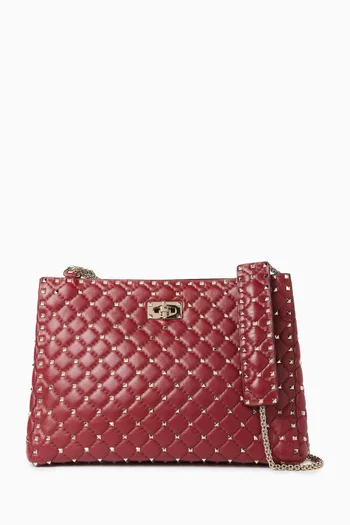 حقيبة يد مبطنة بحلي هرمية مدببة وسلسلة جلد